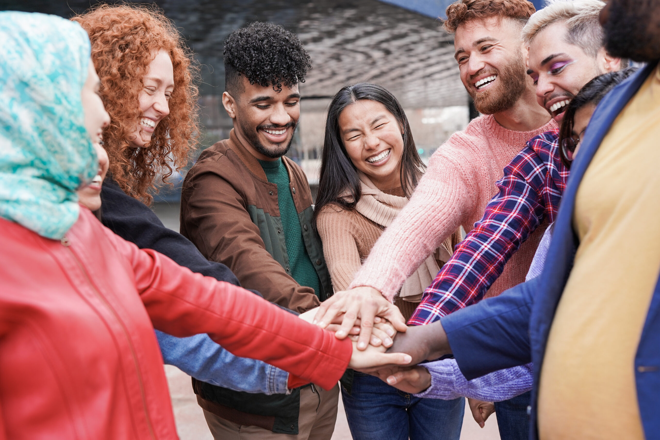 Junge Menschen legen die Hände aufeinander